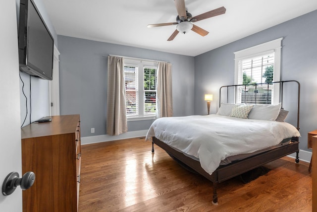 bedroom featuring baseboards, light wood-style flooring, and ceiling fan