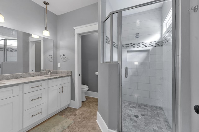 full bath with a stall shower, toilet, double vanity, and tile patterned floors