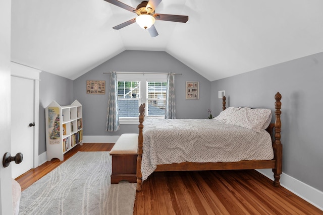 bedroom featuring wood finished floors, ceiling fan, lofted ceiling, and baseboards