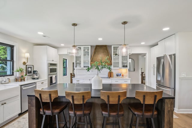 4151 Sadlersville Rd, Adams, TN 37010 - kitchen featuring appliances with stainless steel finishes, glass insert cabinets, a kitchen island, a breakfast bar area, and recessed lighting