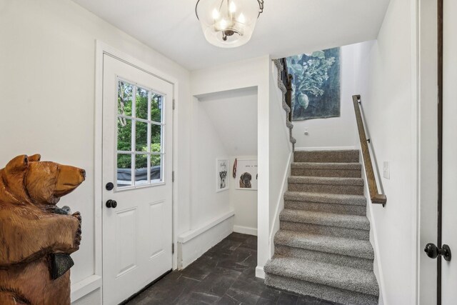 4151 Sadlersville Rd, Adams, TN 37010 - foyer featuring stairs, baseboards, dark stone finish floors, and a chandelier