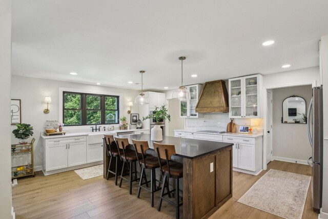 4151 Sadlersville Rd, Adams, TN 37010 - kitchen featuring custom range hood, appliances with stainless steel finishes, a center island, glass insert cabinets, and white cabinets