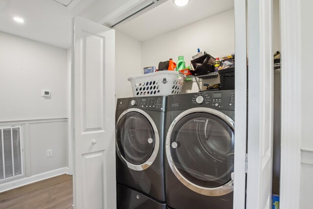 4151 Sadlersville Rd, Adams, TN 37010 - laundry area with wood finished floors, a wainscoted wall, and washing machine and dryer