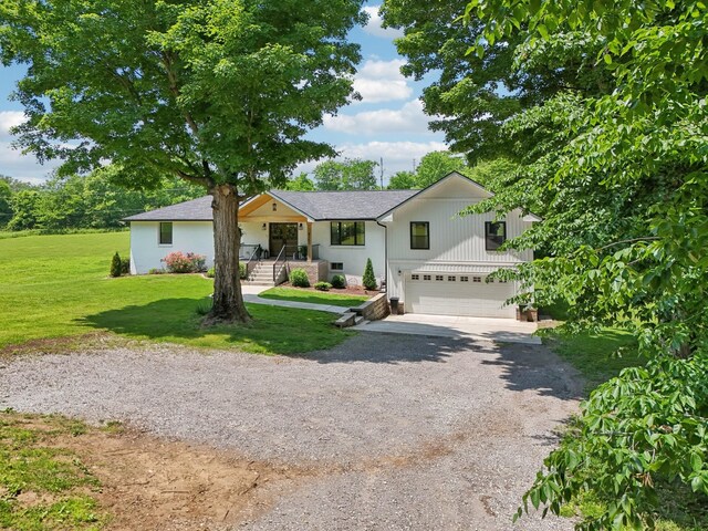 4151 Sadlersville Rd, Adams, TN 37010 - modern farmhouse with gravel driveway, a garage, and a front lawn