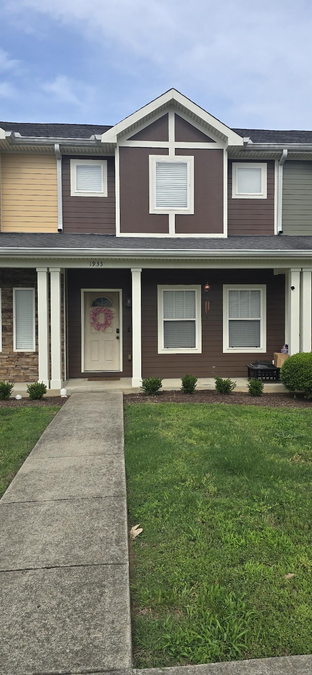 townhome / multi-family property with covered porch and a front yard
