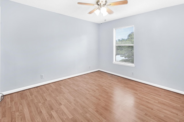 unfurnished room with a ceiling fan, wood finished floors, and baseboards