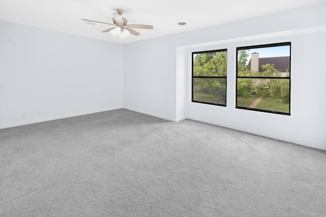 carpeted spare room with baseboards and a ceiling fan