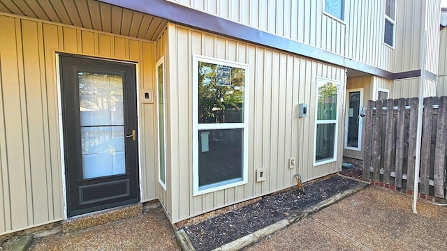 property entrance featuring fence and board and batten siding