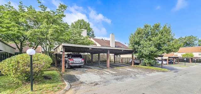 covered parking lot featuring fence