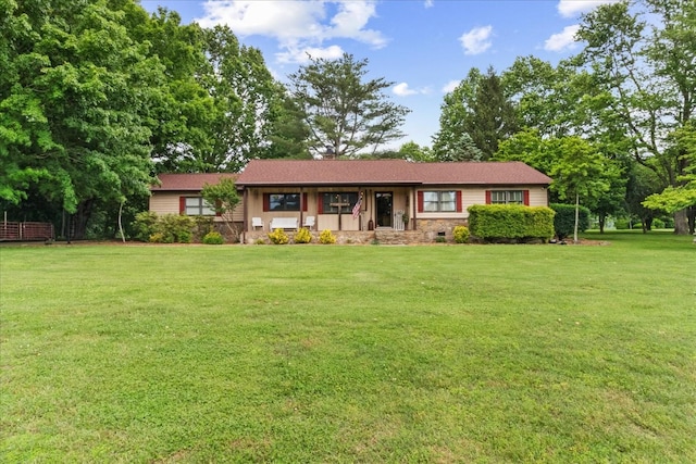 ranch-style home featuring a front lawn and stone siding