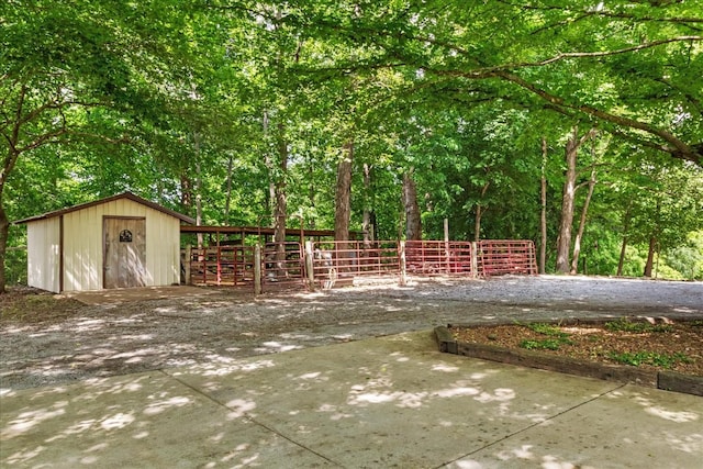 view of patio featuring fence, an outbuilding, and a storage unit