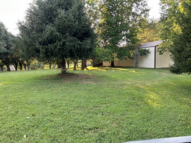 view of green lawn featuring an outbuilding
