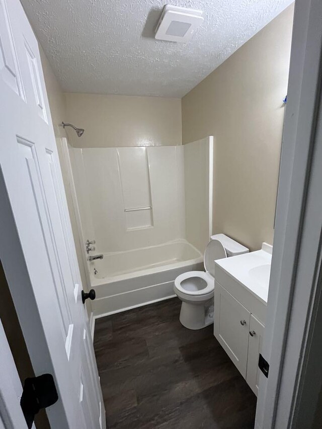 8315 Oak Springs Rd, Nunnelly, TN 37137 - bathroom featuring wood finished floors, a textured ceiling, toilet, bathing tub / shower combination, and vanity