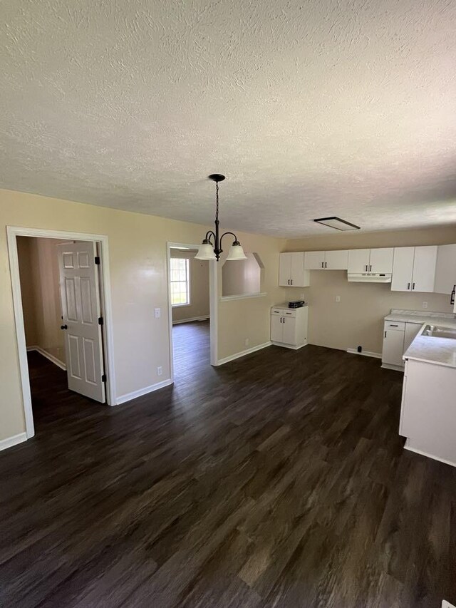 8315 Oak Springs Rd, Nunnelly, TN 37137 - unfurnished living room featuring a textured ceiling, dark wood finished floors, baseboards, a chandelier, and a sink