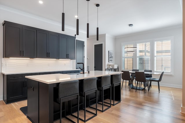 1541 Battlefield Dr Unit A, Nashville, TN 37215 - kitchen with light countertops, crown molding, a breakfast bar area, a kitchen island with sink, and a sink