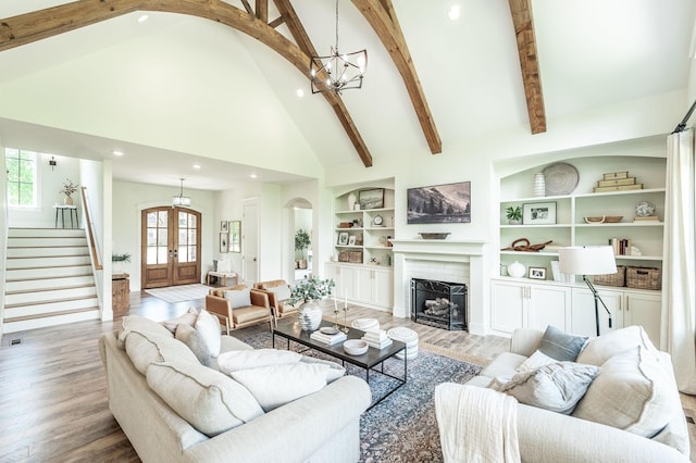 living area with french doors, arched walkways, recessed lighting, a chandelier, and high vaulted ceiling