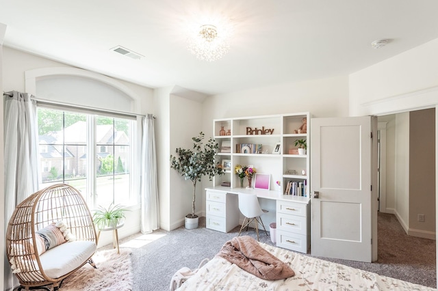 carpeted bedroom with a desk and baseboards