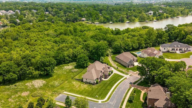 aerial view of residential area with a large body of water and a forest