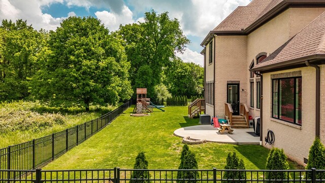 view of yard featuring a patio area, a playground, and entry steps