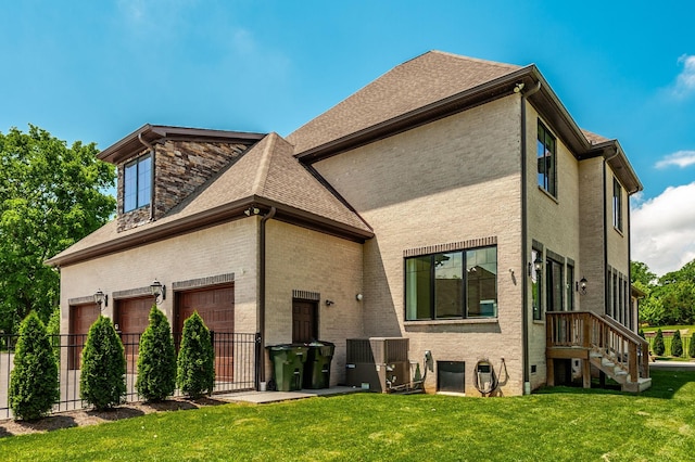 rear view of house featuring a garage, brick siding, and a shingled roof