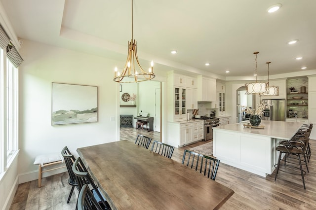 dining area featuring a chandelier, light wood finished floors, recessed lighting, and baseboards
