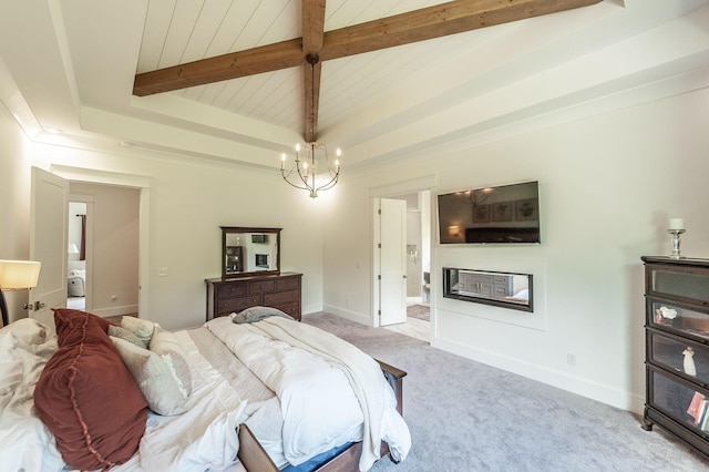 carpeted bedroom featuring a glass covered fireplace, a chandelier, beam ceiling, a raised ceiling, and baseboards