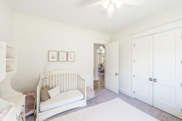 bedroom featuring light colored carpet, a closet, ceiling fan, and baseboards