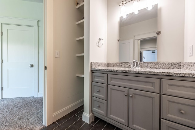 bathroom featuring tile patterned floors, vanity, and baseboards