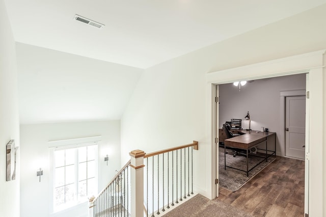 hallway with an office area, lofted ceiling, and dark wood-type flooring