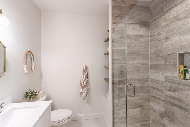 bathroom with a stall shower, vanity, and toilet