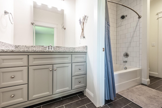 bathroom featuring tile patterned floors, baseboards, shower / bath combo with shower curtain, and vanity