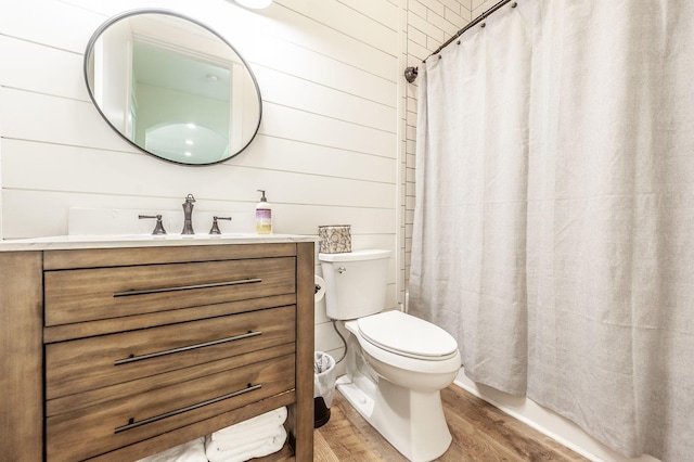full bathroom featuring wood finished floors, toilet, vanity, curtained shower, and wooden walls