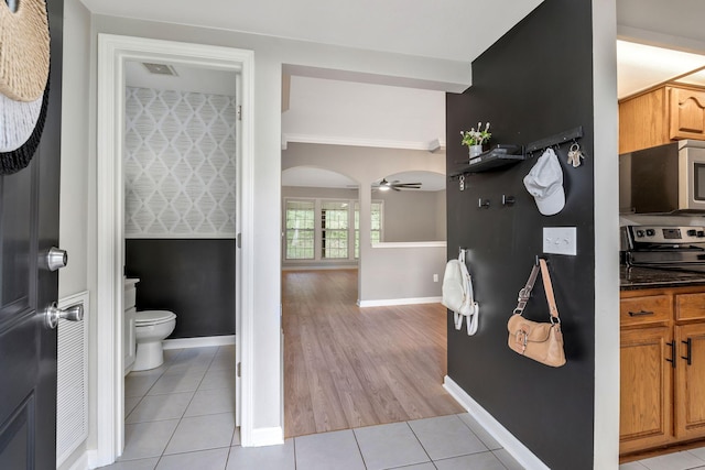 123 Eastdale Ln, Dickson, TN 37055 - kitchen featuring appliances with stainless steel finishes, ceiling fan, light tile patterned floors, baseboards, and arched walkways