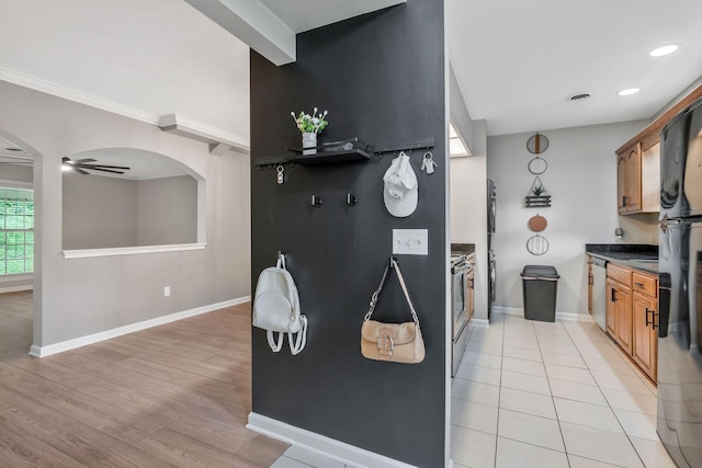 123 Eastdale Ln, Dickson, TN 37055 - kitchen featuring brown cabinets, baseboards, stainless steel appliances, arched walkways, and dark countertops