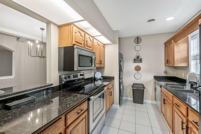123 Eastdale Ln, Dickson, TN 37055 - kitchen featuring stainless steel appliances, a sink, stacked washer and clothes dryer, light tile patterned floors, and dark stone countertops