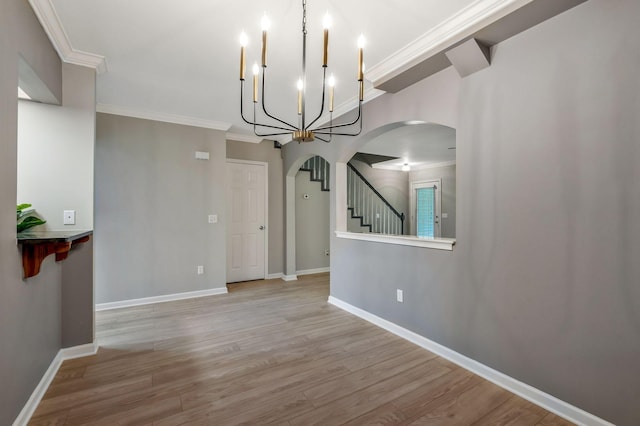 123 Eastdale Ln, Dickson, TN 37055 - unfurnished dining area featuring arched walkways, a chandelier, light wood finished floors, baseboards, and ornamental molding