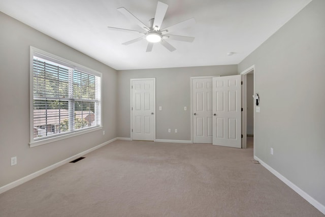 123 Eastdale Ln, Dickson, TN 37055 - unfurnished bedroom with light colored carpet, multiple closets, baseboards, and a ceiling fan