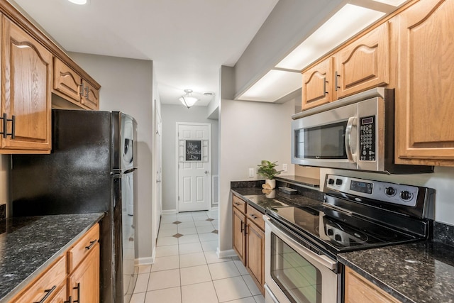 123 Eastdale Ln, Dickson, TN 37055 - kitchen with appliances with stainless steel finishes, light tile patterned floors, dark stone countertops, and baseboards
