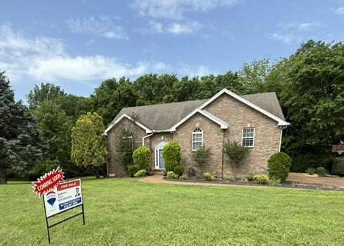 ranch-style house with a front lawn and brick siding