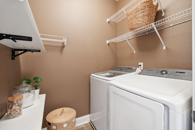 laundry area featuring washer and clothes dryer, baseboards, and tile patterned floors