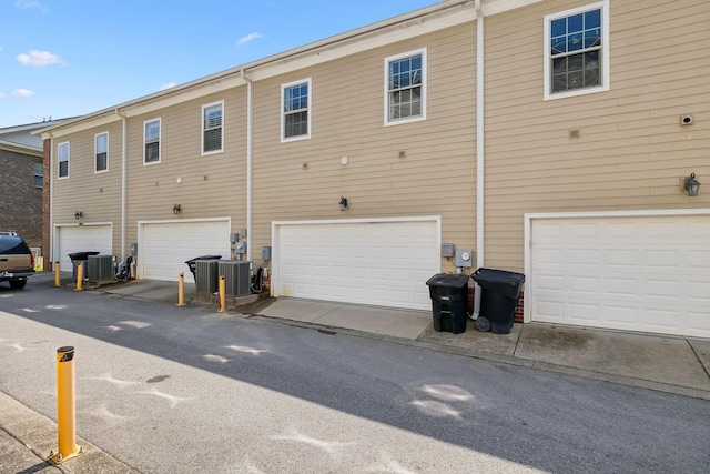 back of property with central air condition unit and an attached garage