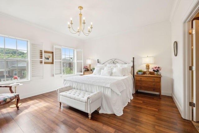 bedroom featuring a chandelier, crown molding, wood finished floors, and baseboards