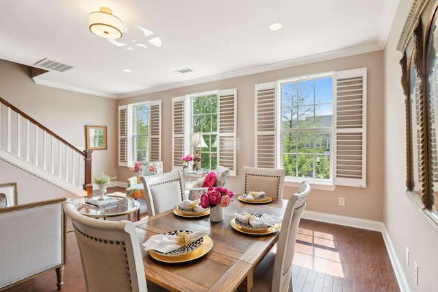 dining room featuring baseboards, crown molding, hardwood / wood-style flooring, recessed lighting, and stairs