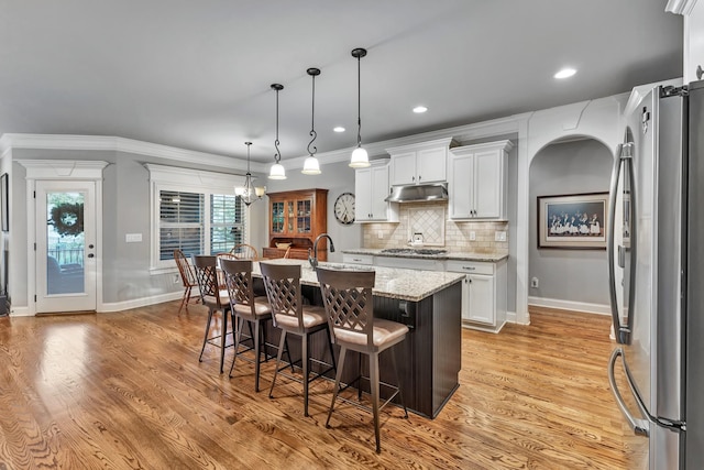 6018 Trotwood Ln, Spring Hill, TN 37174 - kitchen with stainless steel appliances, under cabinet range hood, light wood-type flooring, tasteful backsplash, and recessed lighting