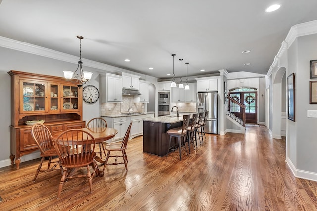 6018 Trotwood Ln, Spring Hill, TN 37174 - dining space featuring arched walkways, dark wood finished floors, baseboards, recessed lighting, and crown molding