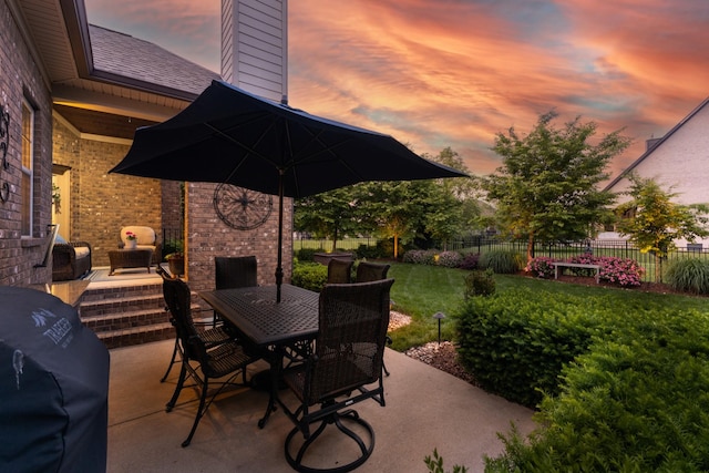 6018 Trotwood Ln, Spring Hill, TN 37174 - patio terrace at dusk with an outdoor brick fireplace and outdoor dining area