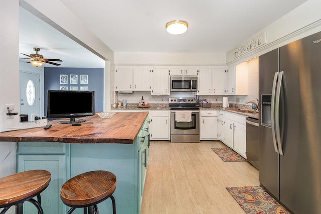 247 High Cliff Dr, Hendersonville, TN 37075 - kitchen featuring stainless steel appliances, wooden counters, white cabinets, light wood-type flooring, and a breakfast bar area