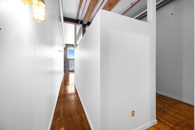 hallway featuring wood-type flooring and baseboards