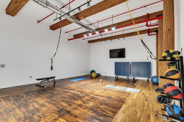 workout room with hardwood / wood-style flooring and baseboards
