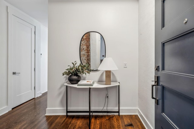 entrance foyer featuring baseboards and dark wood finished floors